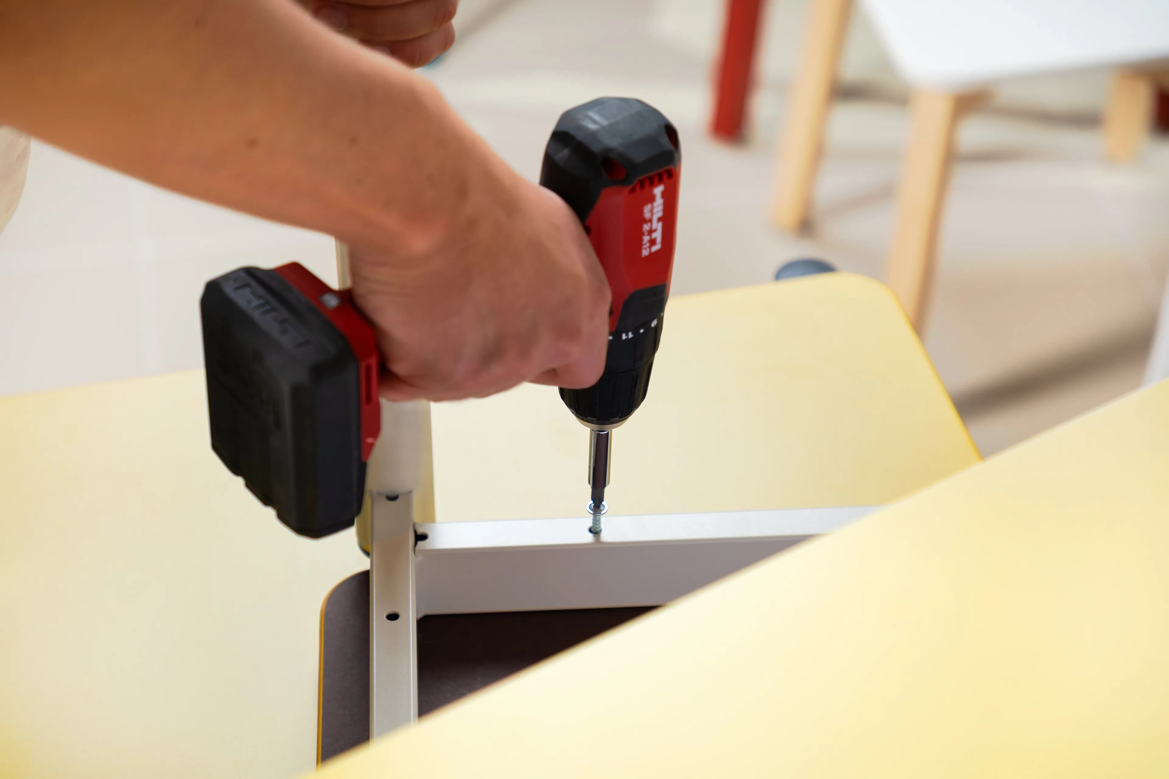 Image of a furniture installer assembling the base of a bench.